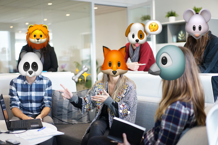 A photograph of six people at the office. Thier faces have been concealed with emoji animal heads and extra emoji have been added for comic effect.